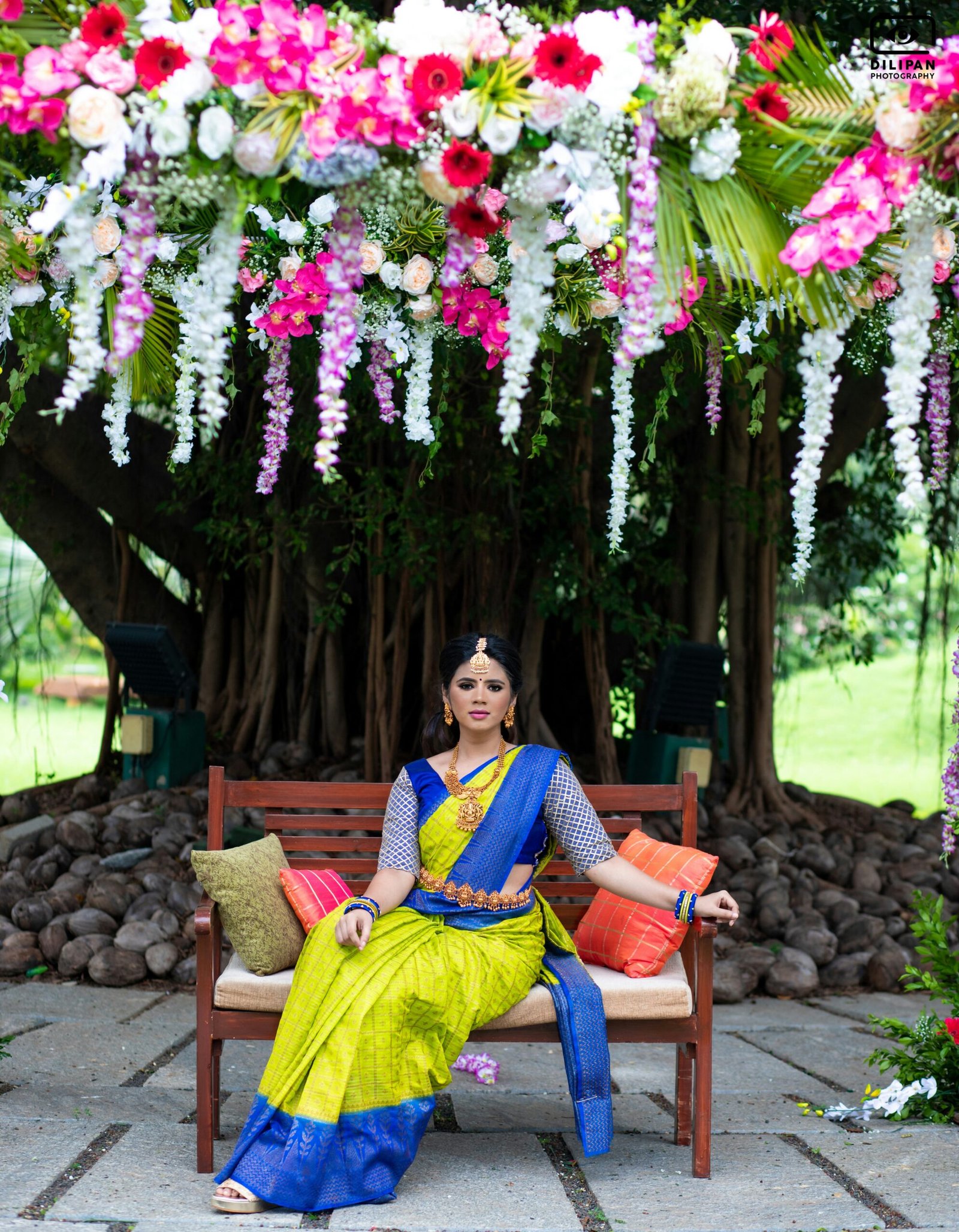 a woman sitting on a bench in front of a tree